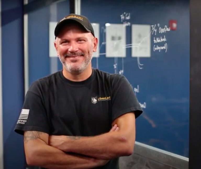 smiling employee in a baseball hat and black tshirt