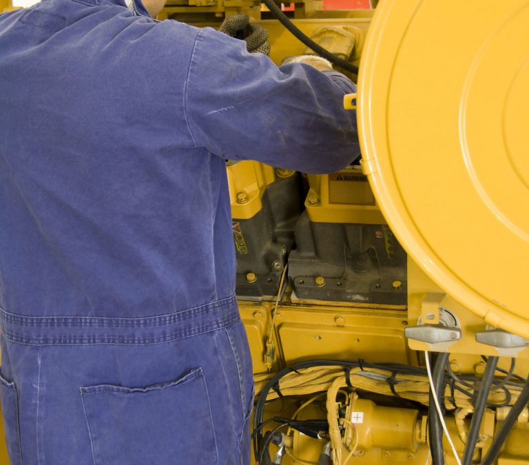 back and upper right arm of an employee working on a yellow commercial generator