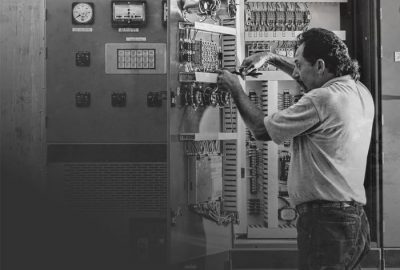 black and white aged picture of an electrician working on a circuit board