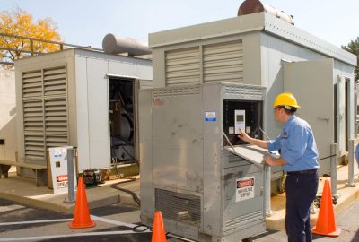 tech in yellow hard hat working with a lordtec load bank