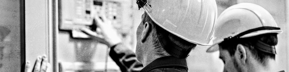 two men in hard hats looking away from the camera