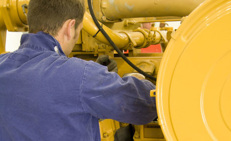 close up view of yellow generator from over a man's shoulder